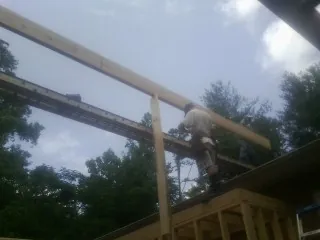 Carpenter setting a ridge beam over a new addition frame — Ice Dam Removal by Roofing Brothers in Tilghman
