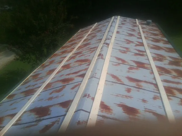 Rusted metal roof panels with new wood purlins before replacement — Storm Damage Roof Repair in Tilghman by Roofing Brothers