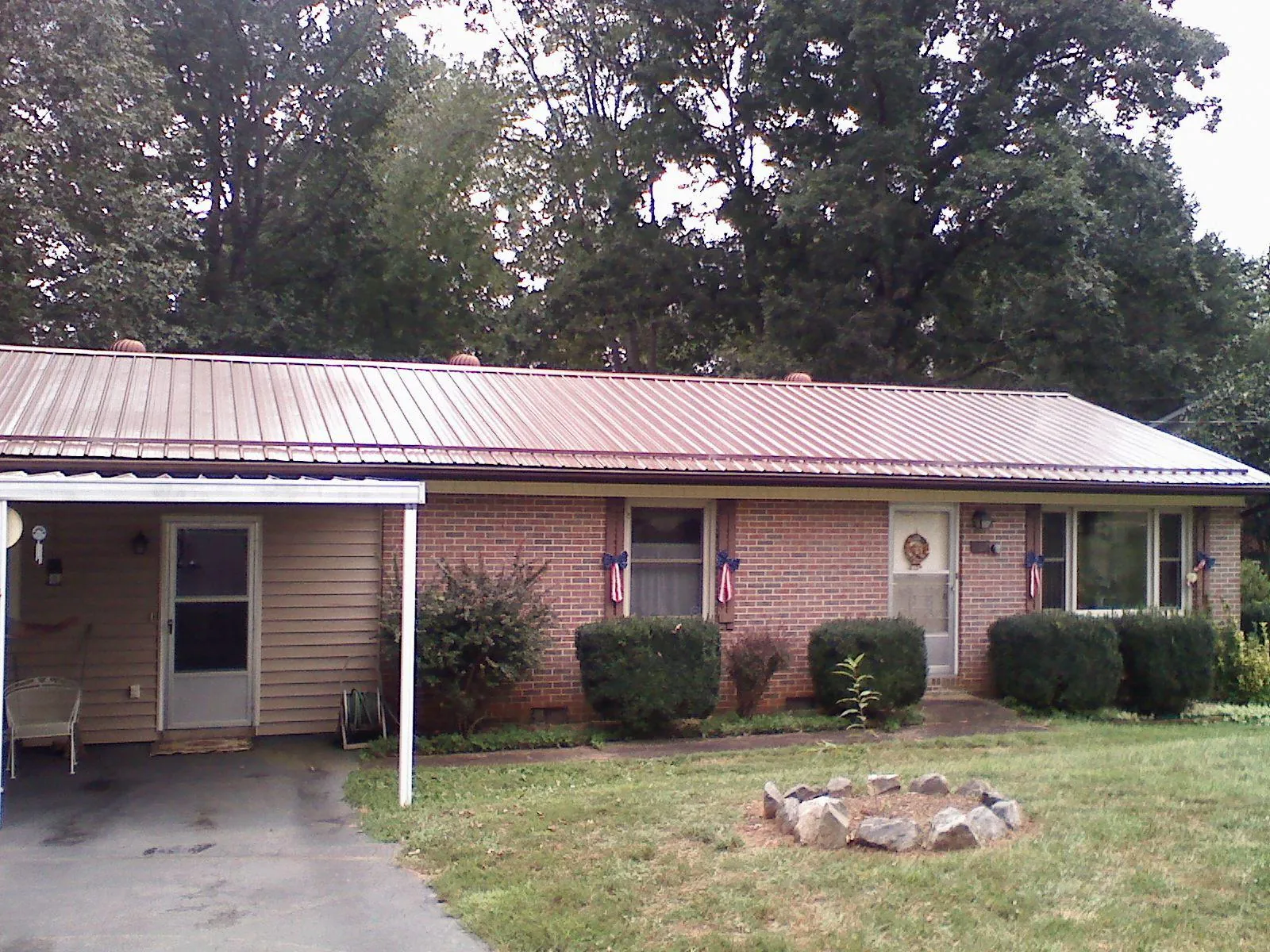 Bronze metal roof and carport on a brick ranch home — Roof Repair work by our crew in Tilghman